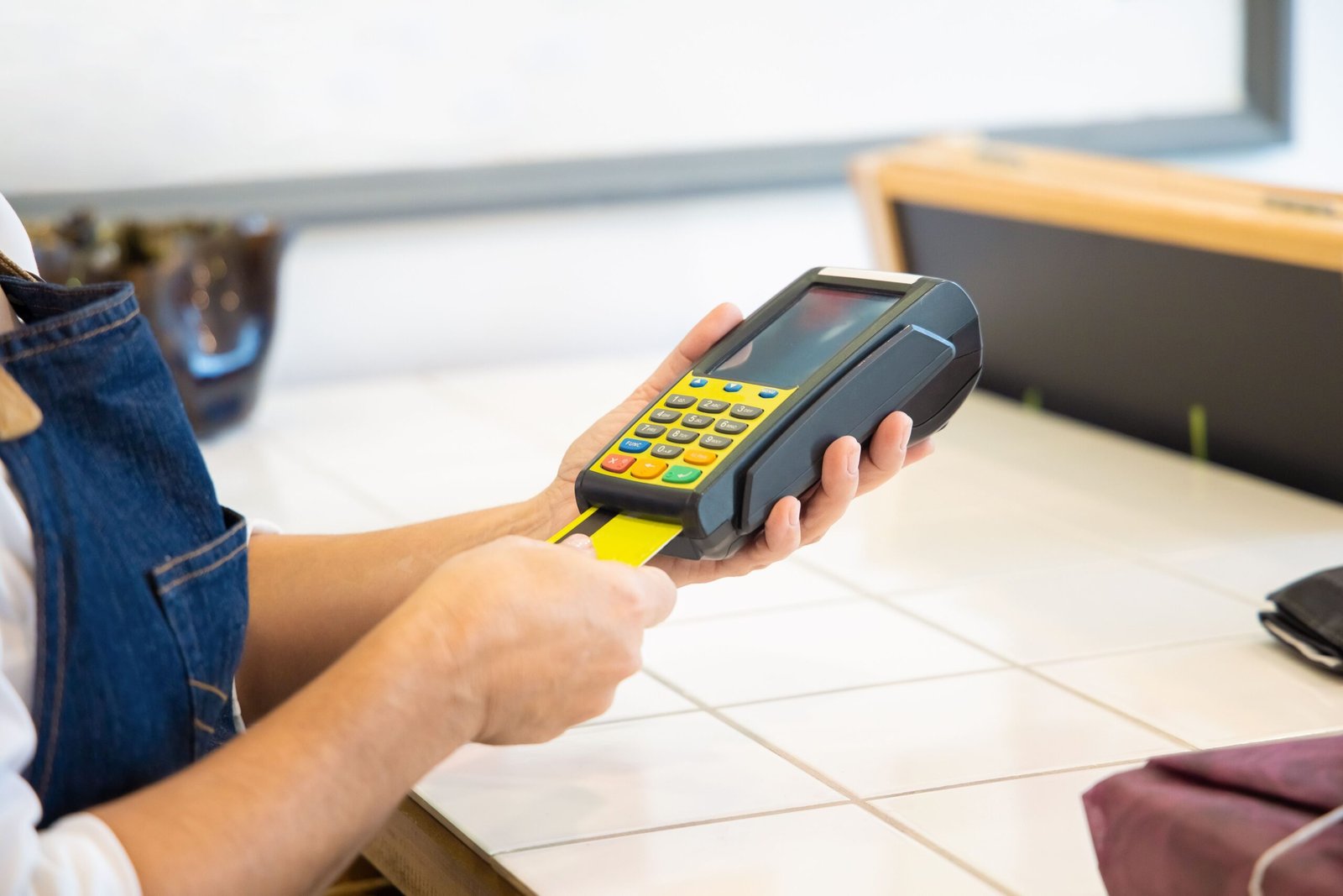 Small business owner taking card payments in a shop