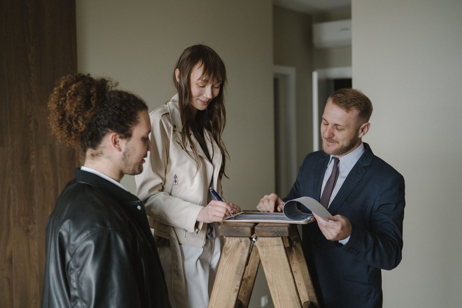 Couple signing mortgage documents with a loan officer